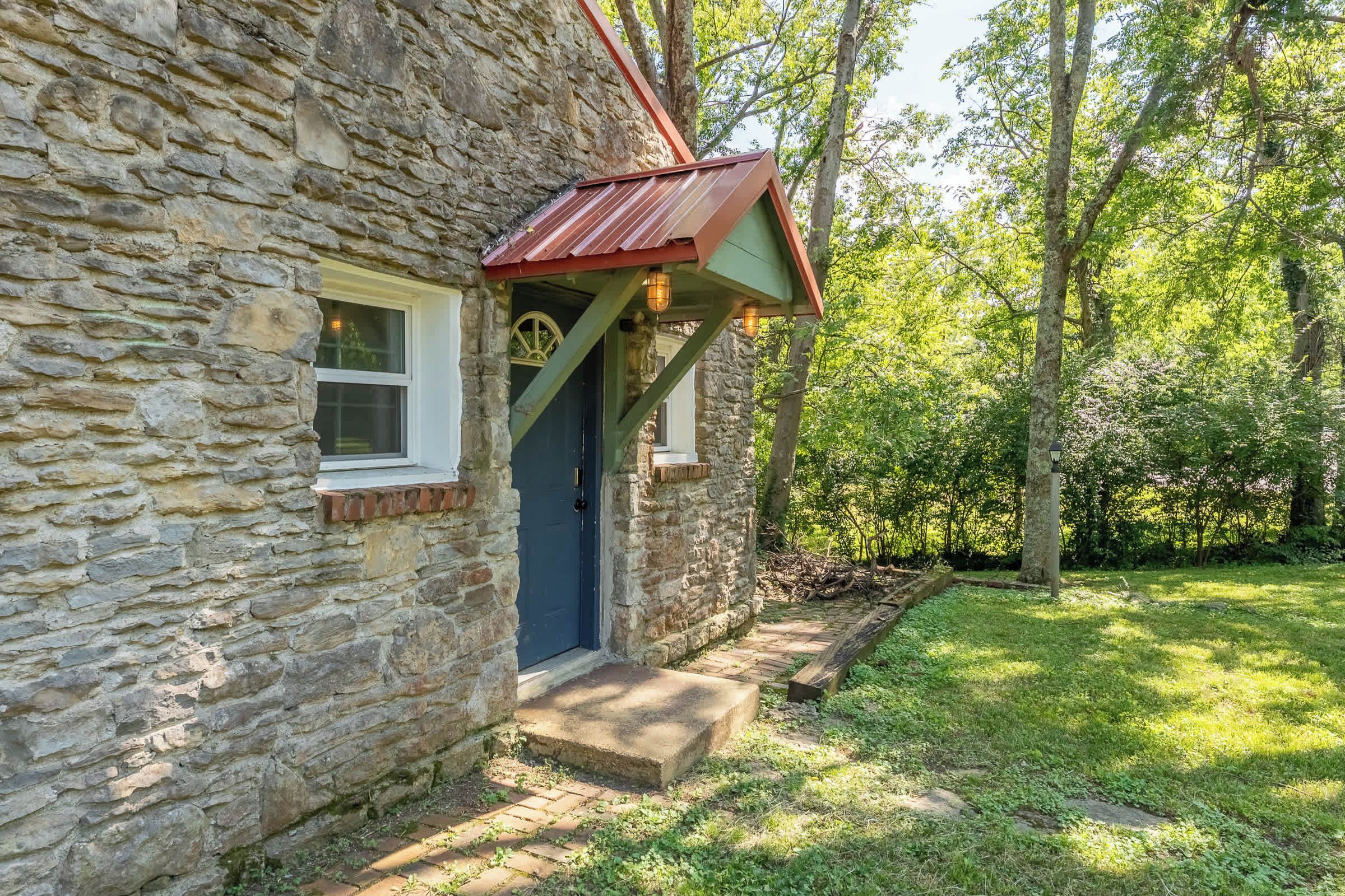 A stone building with a small porch and a window.