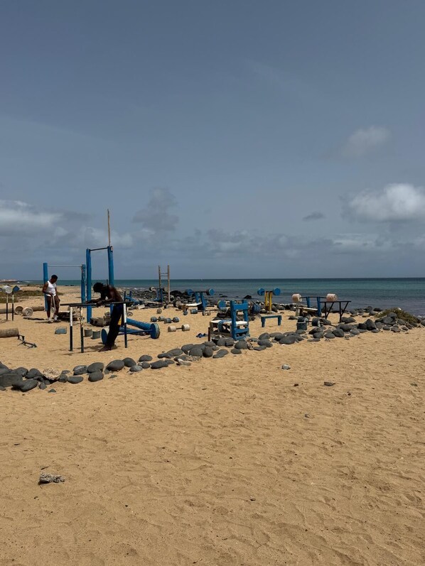 A beach with exercise equipment and rocks. - Refugio Hachi (8 people) (Santa Maria)