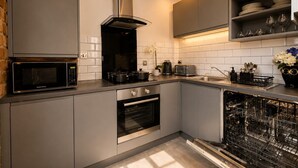 A modern kitchen with a microwave, oven, and dishwasher. - City Centre Apt–Sleeps 6, Parking, Shops & Trains (Merseyside)