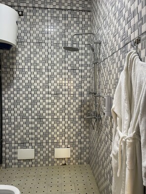 Senior suite, uitzicht op de stad | Badkamer | Een douche, pantoffels, handdoeken, zeep