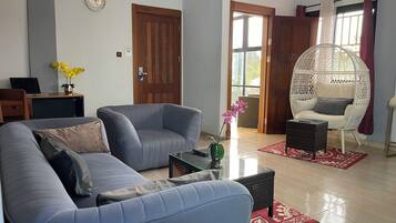 Suite senior, vista a la ciudad | Área de sala de estar | Smart TV de 80 pulgadas con canales vía satélite