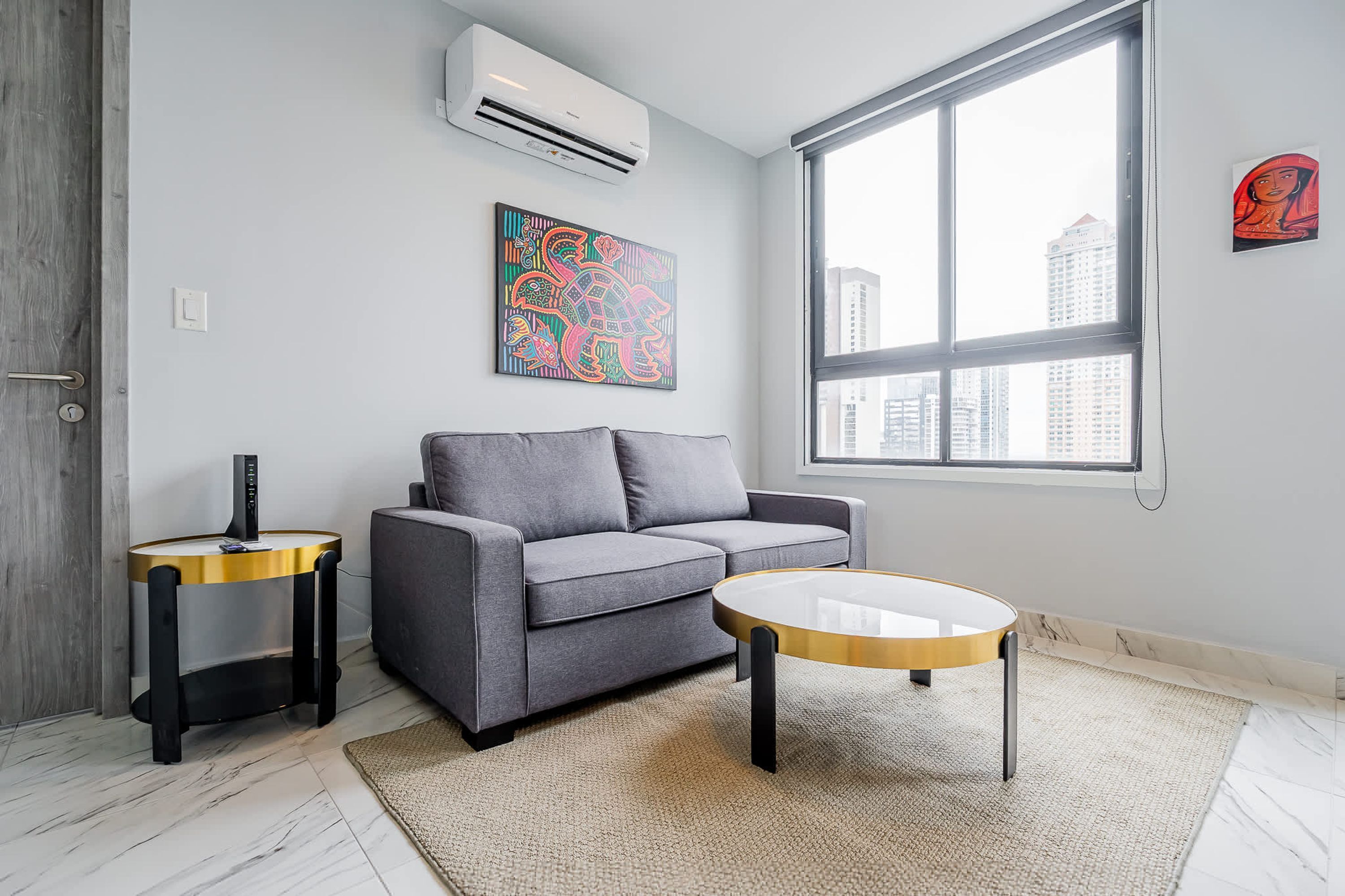 A modern living room with a grey sofa, a round coffee table, and a side table.