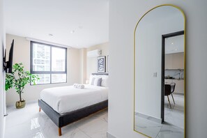 A modern bedroom with a large bed, a potted plant, a flat-screen TV, and a view of the city through a large window. - w Scenic 1BR w Panoramic City View in Calle 50 (Panama City)