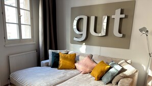Een moderne slaapkamer met een groot bed, een aan de muur bevestigd 'gut'-bord en een radiator.