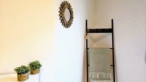 A room with a wooden chair, a woven basket with a plant, and a wall-mounted mirror. - Your Central Base in Historic Tarazona (Tarazona)