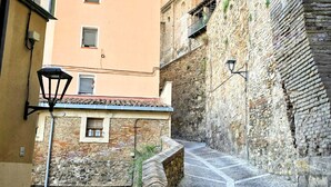 A narrow cobblestone street flanked by historic stone buildings, one with a bell tower. - Your Central Base in Historic Tarazona (Tarazona)
