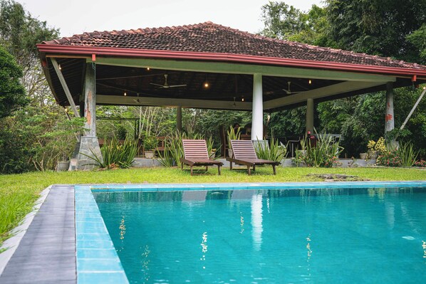 Una piscina al aire libre, tumbonas