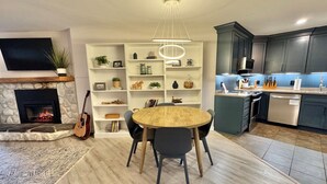 Una cocina moderna con armarios oscuros, horno empotrado y lavavajillas.