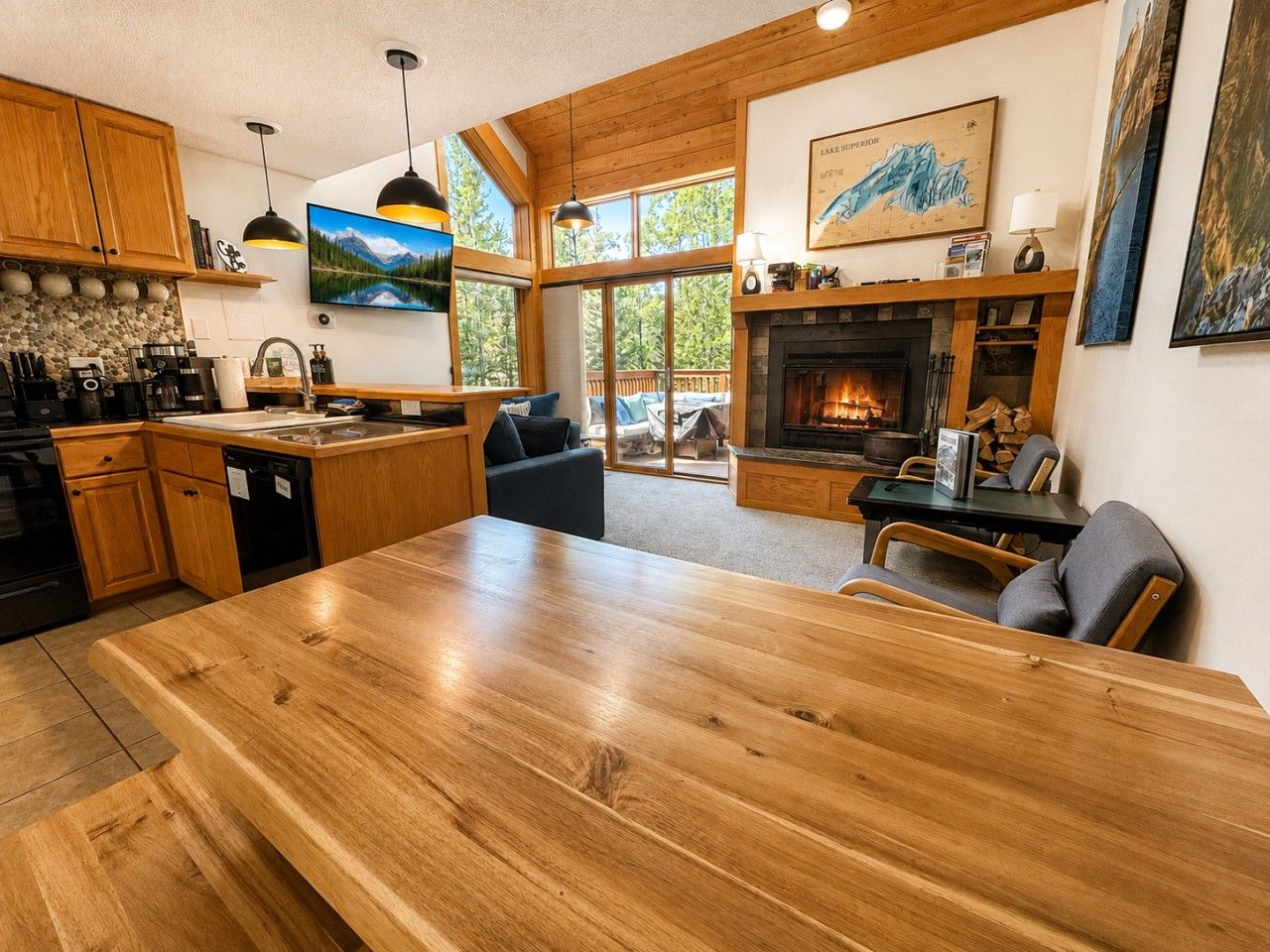 Une cuisine spacieuse avec une grande table en bois, des placards en bois et une cheminée.
