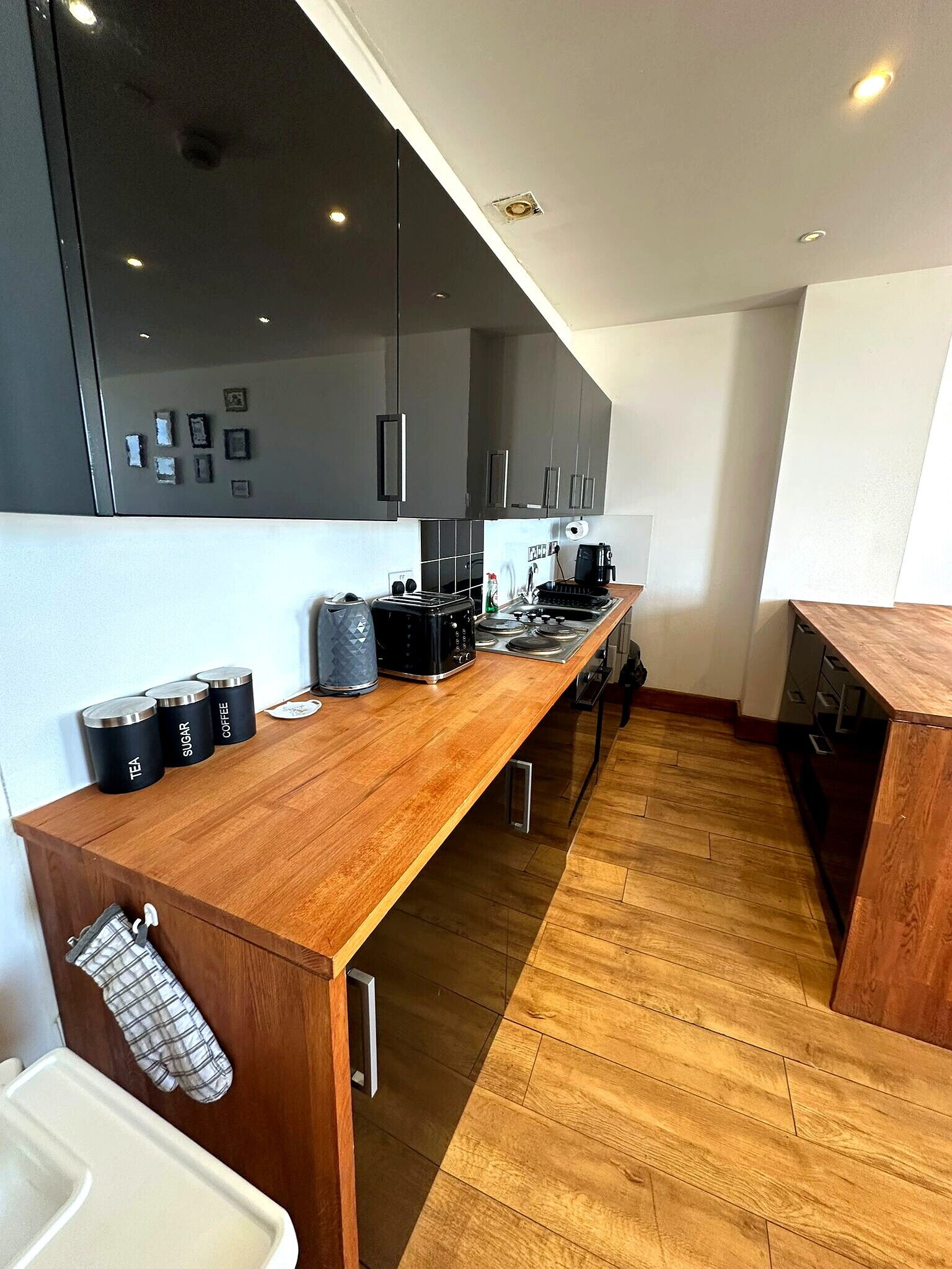 Una cucina moderna con piano in legno, elettrodomestici in acciaio inossidabile e una grande finestra.