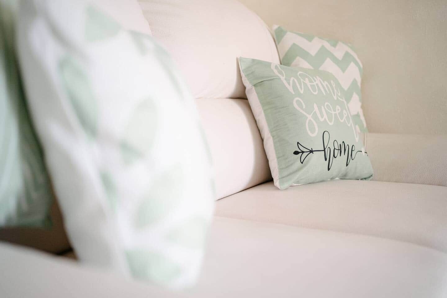 Ein Sofa mit zwei Kissen, eines mit Zickzackmuster und das andere mit Text.