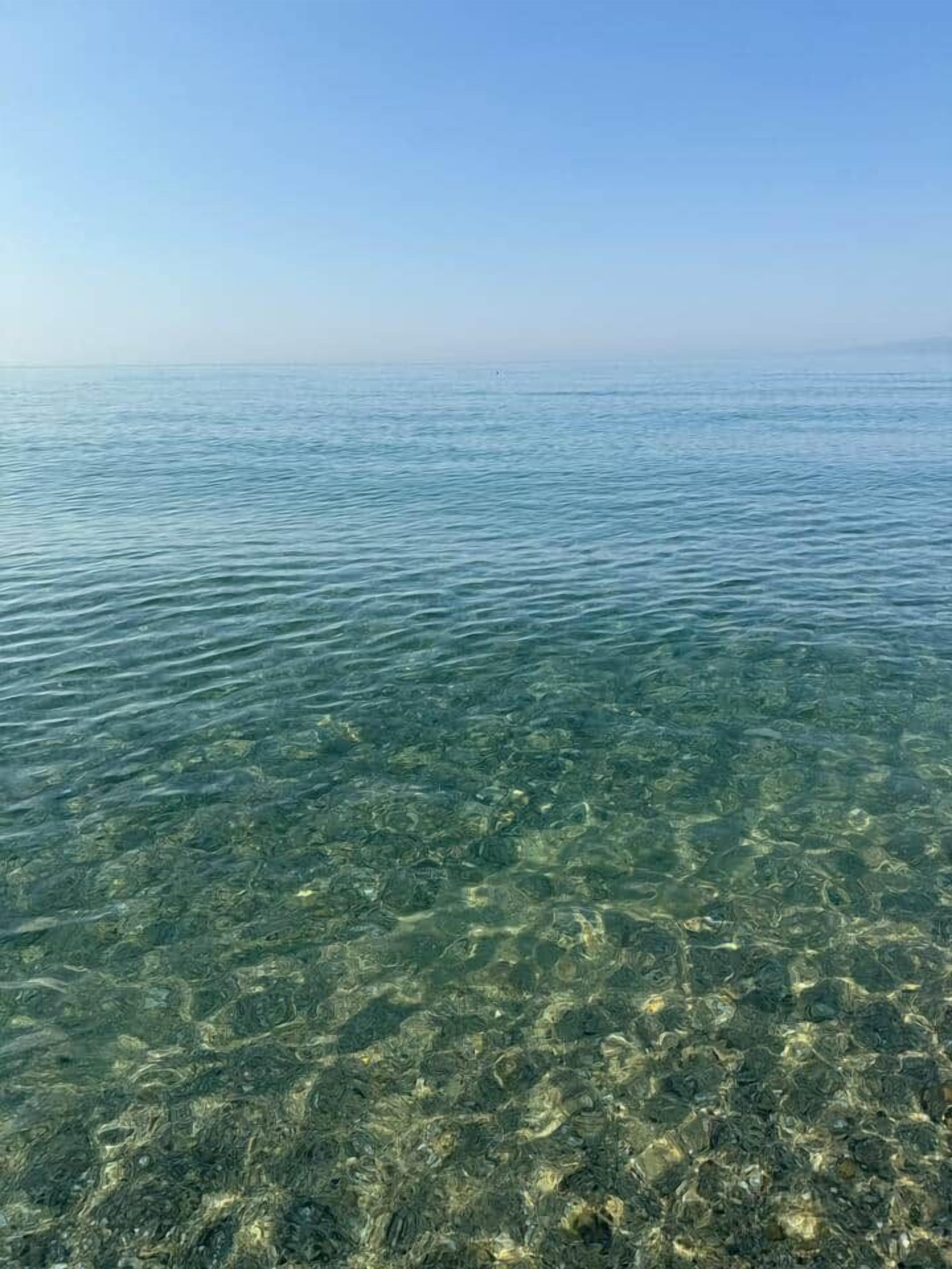 Una vista despejada de un mar tranquilo con terreno submarino visible.