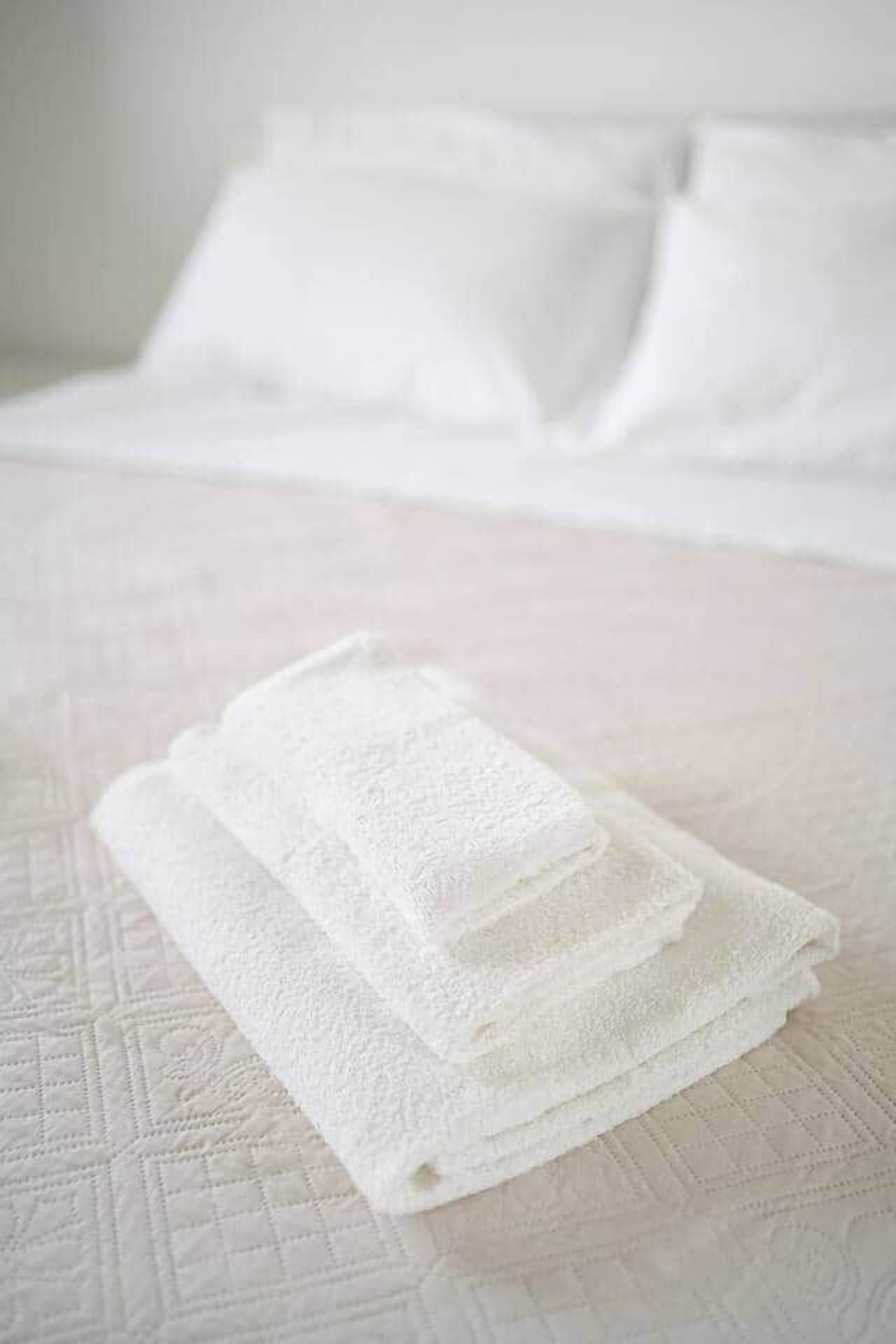 Un lit bien fait, avec du linge de lit blanc et des oreillers.