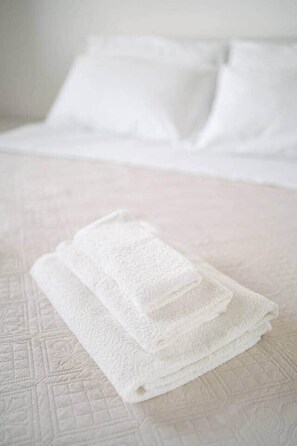 A neatly made bed with white linens and pillows. - Casa Cleo - Ocean & Pine Forest (Villaggio Carrao)