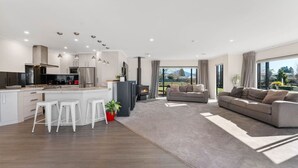 Eine moderne Küche mit einer zentralen Kochinsel, Barhocker und einem Kamin.