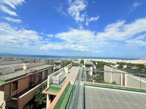 A rooftop terrace with a view of the sea, featuring multiple buildings with flat roofs and a clear sky. - Deluxe Villa Beach Front (Cam Lam)