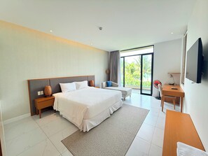 A modern hotel room with a large bed, a desk, and a TV. - Deluxe Villa Beach Front (Cam Lam)