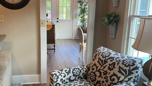 Un salon avec un canapé à motifs, une horloge et un lustre.