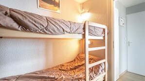 A bunk bed room with a wooden ladder, a white door, and a wall-mounted light fixture. - Valley-view Apartment in Chamrousse (Chamrousse)