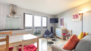 A compact living space with a kitchen, dining area, and seating area. - Valley-view Apartment in Chamrousse (Chamrousse)