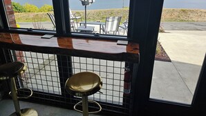 A bar area with a view of a large body of water and distant land. - Industrial modern house with Water Views – Walk to the waterfront (Tacoma)