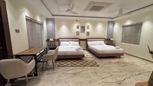 Habitación de hotel con dos camas, un escritorio y sillas.