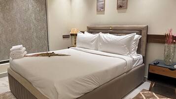Une chambre à coucher moderne avec un grand lit, une table de chevet, une lampe et un vase décoratif.