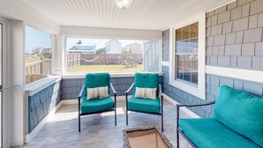 A sunroom with two green chairs, a bench, and a view of a backyard. - KH3111B: Seas the Day | Walk to Beach | Patio | Kitchenette (Kitty Hawk)