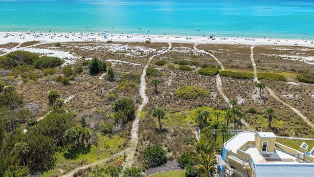 An aerial view of a beach with clear turquoise waters, sandy shore, and sparse vegetation. - Beautiful Townhouse 1/2 Block From Siesta key Village & The Beach! (Siesta Key)