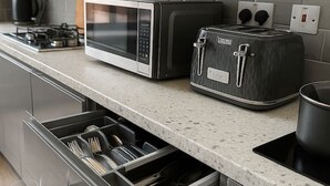 A modern kitchen with a built-in microwave, toaster, and oven.