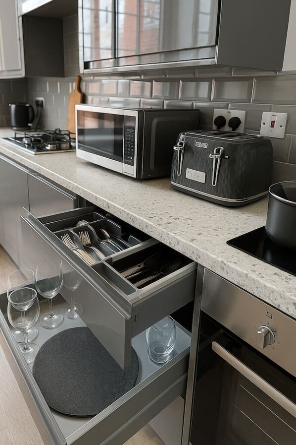A modern kitchen with a built-in microwave, toaster, and oven.