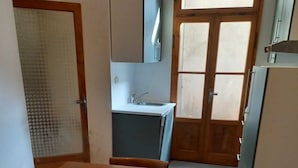 A compact kitchen with a wooden table, a sink, and cabinets. - GREEN DOLOMYTE Apartment (Schilpario)