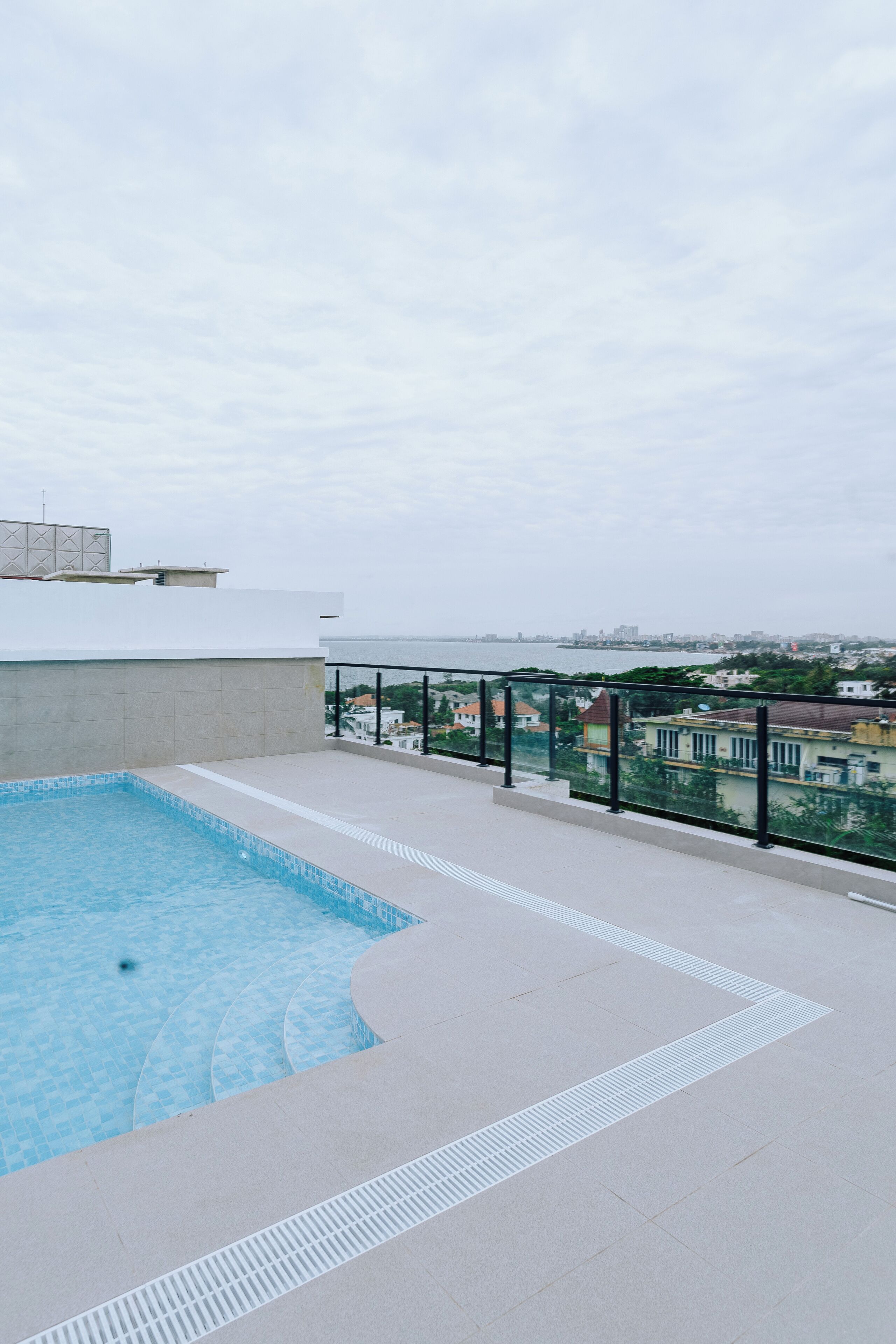 A rooftop pool with a clear view of the city skyline in the background.