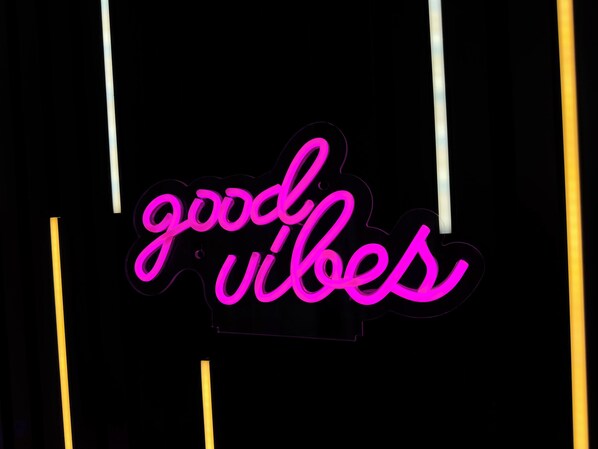 Un letrero de neón con la inscripción 'good vibes' sobre un fondo oscuro.