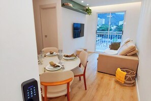 Un salon moderne comprenant un coin repas, un canapé, un téléviseur et un balcon avec vue.
