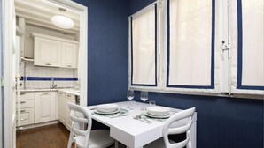 A compact kitchen with white cabinets, a white countertop, and a window with blinds. - Fossi Street Central Apartment (Florence)