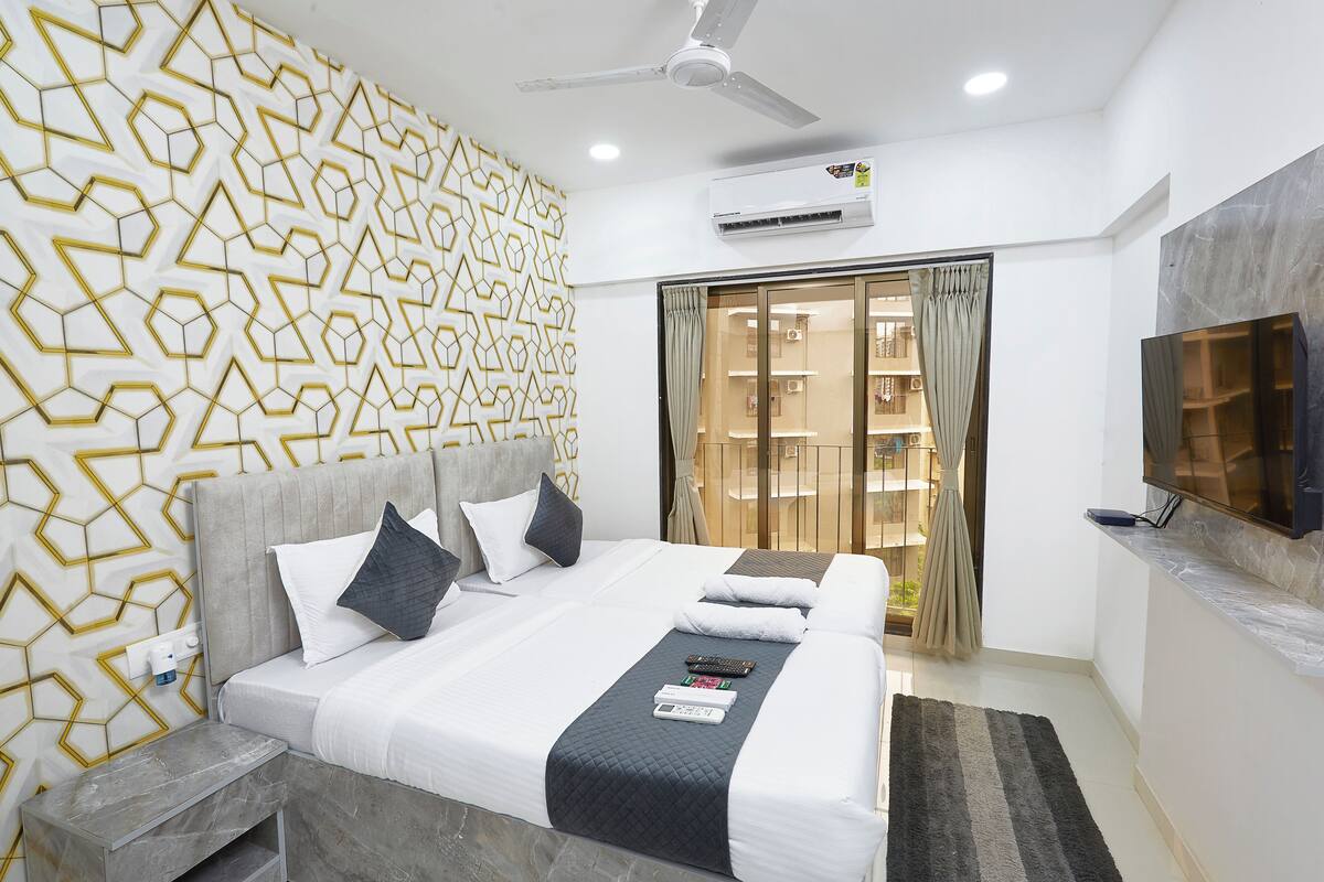 Une chambre d’hôtel avec un lit, une télévision et un ventilateur de plafond.