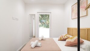 A bedroom with a bed, a door leading outside, and a window. - Waou Terrace House III (Madrid)