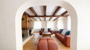 Un interno con camino, travi in legno, un divano e un tavolino da caffè.