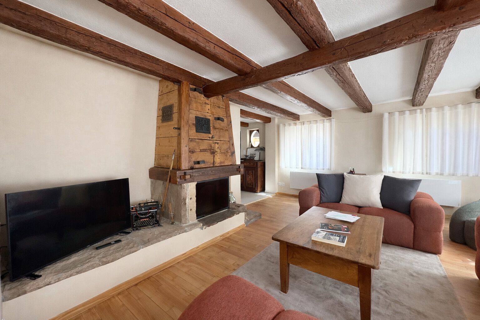 A living room with a fireplace, a television, a sofa, and a coffee table.