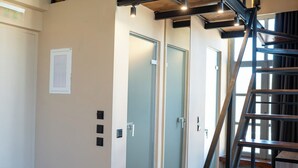 Ein modernes Interieur mit einer Holztreppe, einem Glastür-Eingang und einem hellen Boden.