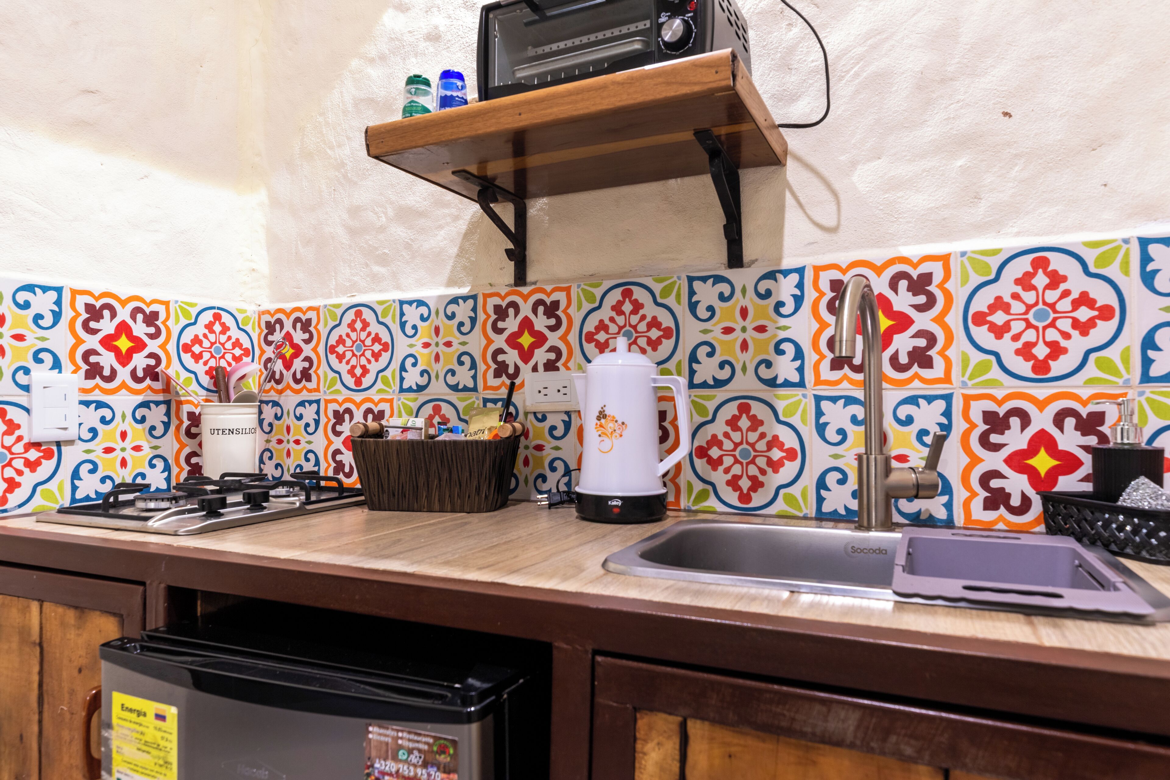 A kitchen with a gas stove, a coffee maker, a toaster, and a sink.