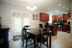 A modern kitchen with wooden cabinets, a central island, and stainless steel appliances.