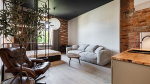 Ein modernes Wohnzimmer mit Ledersofa, Couchtisch aus Holz und einer Ziegelwand.