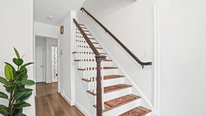 Eine Treppe mit Holzdielen und Geländer, die zu einer oberen Etage führt.