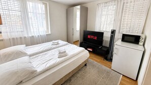 Une chambre d’hôtel équipée d’un lit, d’une télévision, d’un four à micro-ondes et d’un réfrigérateur.
