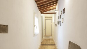 A narrow hallway with wooden flooring, white walls, and a door at the end. - Santa Maria Novella Top Floor Hideaway (Firenze)