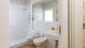 A modern bathroom with a glass-enclosed shower, a double sink, and a toilet. - Santa Maria Novella Top Floor Hideaway (Firenze)