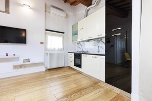 A modern kitchen with white cabinets, a marble backsplash, and a built-in dishwasher. - Santa Maria Novella Top Floor Hideaway (Firenze)