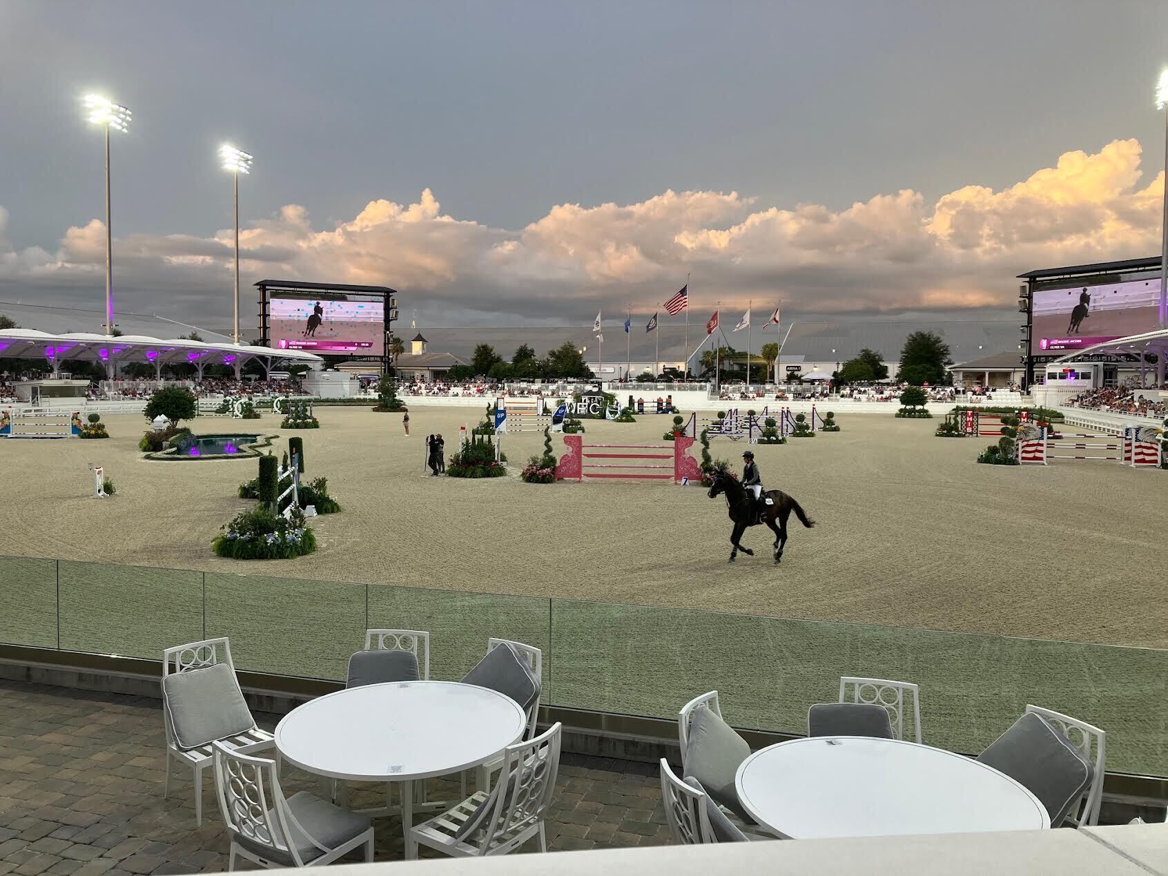 An outdoor equestrian arena with a seating area and tables.